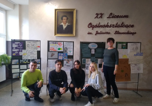 1. Uczniowie wraz z nauczycielką chemii Honoratą Życką na tle plakatów dotyczących liczby molowej