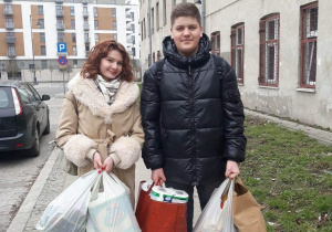 Uczniowie niosący podarunki dla domu dziecka